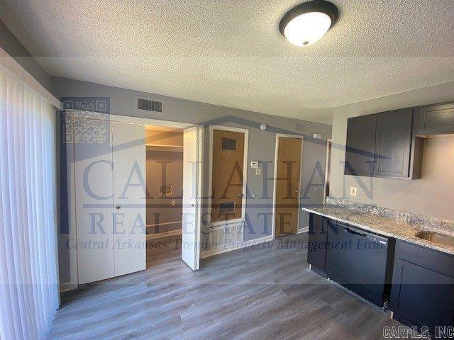 5732 Camp Robinson Rd, North Little Rock, AR 72118 - kitchen featuring a textured ceiling, light countertops, visible vents, and wood finished floors