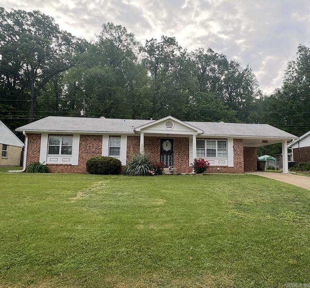 ranch-style home with a front yard, a carport, brick siding, and driveway