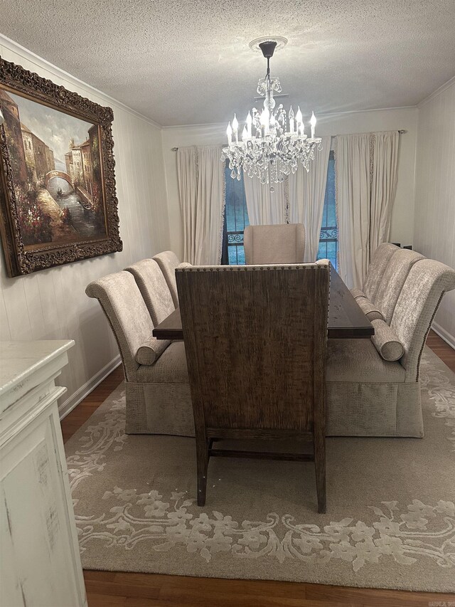 dining room with an inviting chandelier, crown molding, and wood finished floors