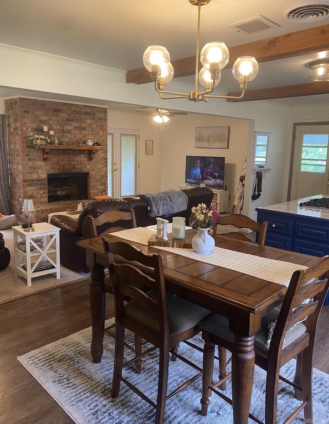804 Elm St, Smackover, AR 71762 - dining room with dark wood-style floors, a fireplace, and a chandelier