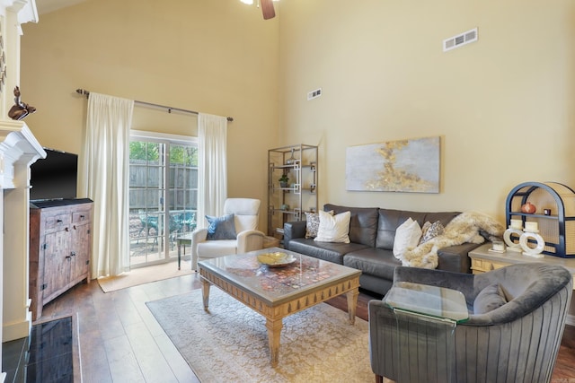 living area with wood-type flooring, high vaulted ceiling, and visible vents