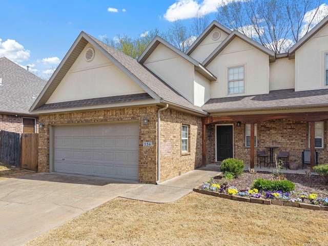 view of front of property with concrete driveway, stucco siding, and brick siding