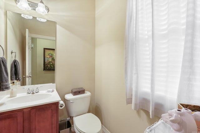 half bathroom featuring vanity and toilet