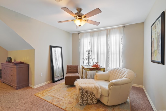 sitting room featuring carpet, baseboards, and a ceiling fan
