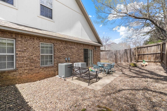 rear view of property featuring central AC, a patio, and a fenced backyard
