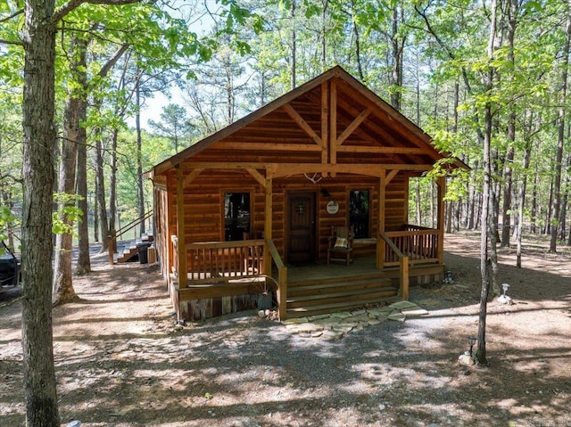 892 Hwy 375 E, Mena, AR 71953 - view of front facade featuring a porch, log veneer siding, and a forest view