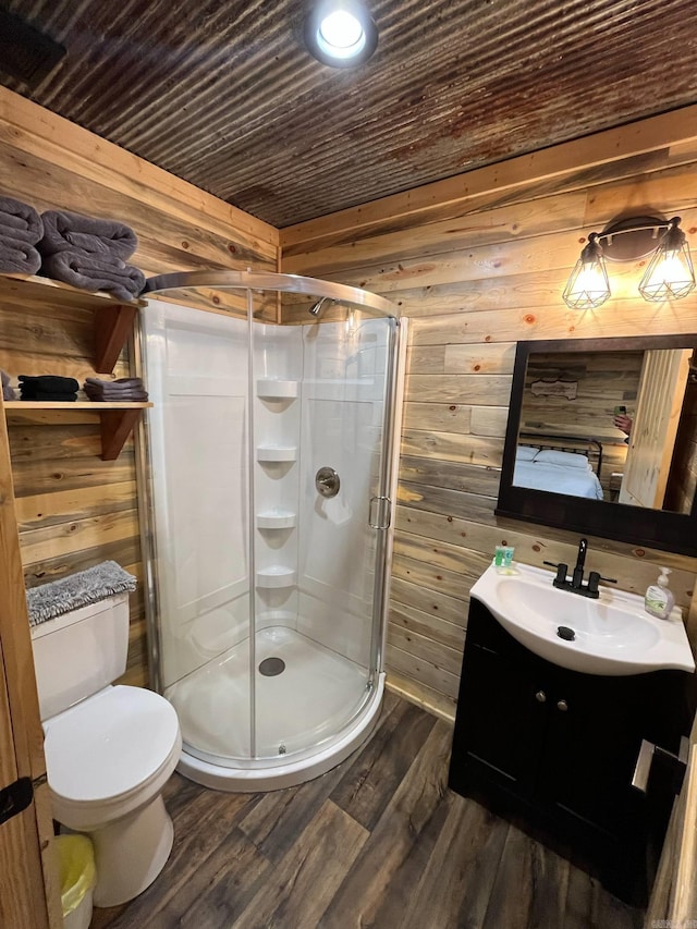 892 Hwy 375 E, Mena, AR 71953 - bathroom with toilet, wood finished floors, vanity, wooden walls, and a shower stall