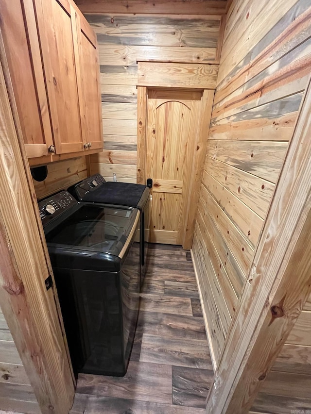 892 Hwy 375 E, Mena, AR 71953 - laundry area with washer and clothes dryer, dark wood-style flooring, wooden walls, and cabinet space