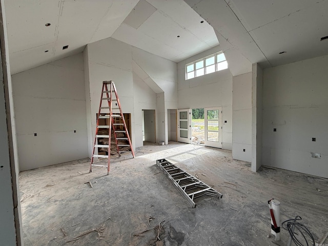 unfurnished living room with high vaulted ceiling