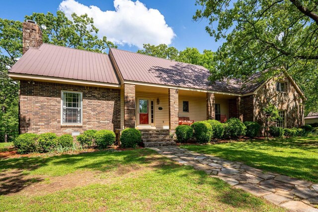 1494 N Miller Point Rd, Quitman, AR 72131 - single story home featuring a chimney, metal roof, a front lawn, a porch, and brick siding