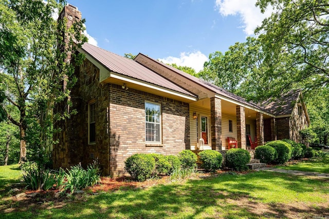 1494 N Miller Point Rd, Quitman, AR 72131 - view of property exterior with brick siding, metal roof, a chimney, and a lawn