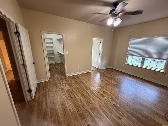 13506 Dynasty Dr, Alexander, AR 72002 - unfurnished bedroom with a closet, wood finished floors, a spacious closet, a ceiling fan, and baseboards