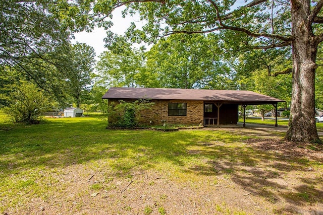 1400 S Rose St, Sheridan, AR 72150 - view of front facade featuring an outdoor structure, a storage shed, brick siding, an attached carport, and a front yard