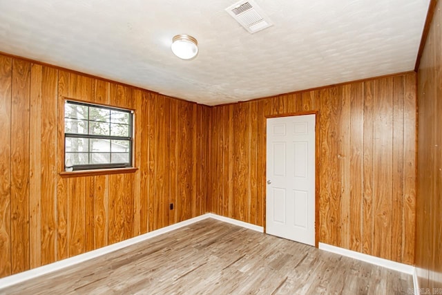 1400 S Rose St, Sheridan, AR 72150 - spare room with visible vents, wood finished floors, baseboards, and wooden walls