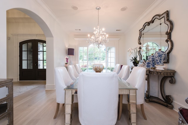 44 Deauville Cir, Little Rock, AR 72223 - dining space with light wood-type flooring, french doors, arched walkways, and a notable chandelier
