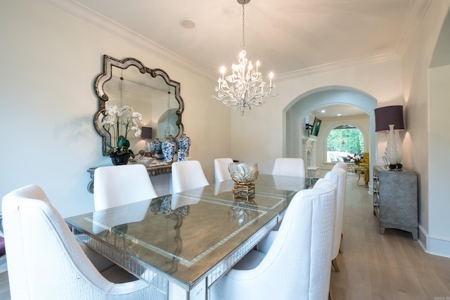44 Deauville Cir, Little Rock, AR 72223 - dining space featuring arched walkways, ornamental molding, an inviting chandelier, and wood finished floors