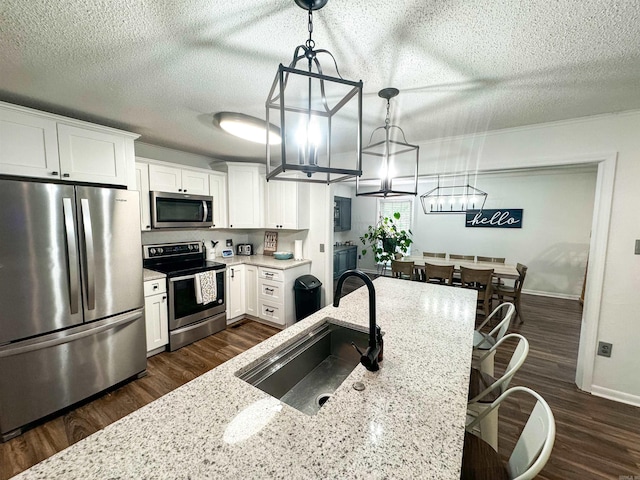 105 Liles, Searcy, AR 72143 - kitchen featuring a textured ceiling, dark wood-style floors, appliances with stainless steel finishes, and a sink