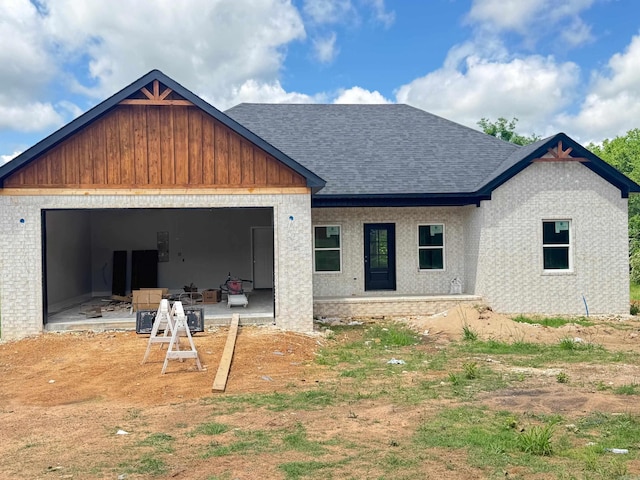 property in mid-construction featuring roof with shingles and a garage