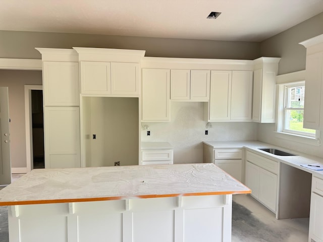 kitchen featuring a sink, a center island, and white cabinets