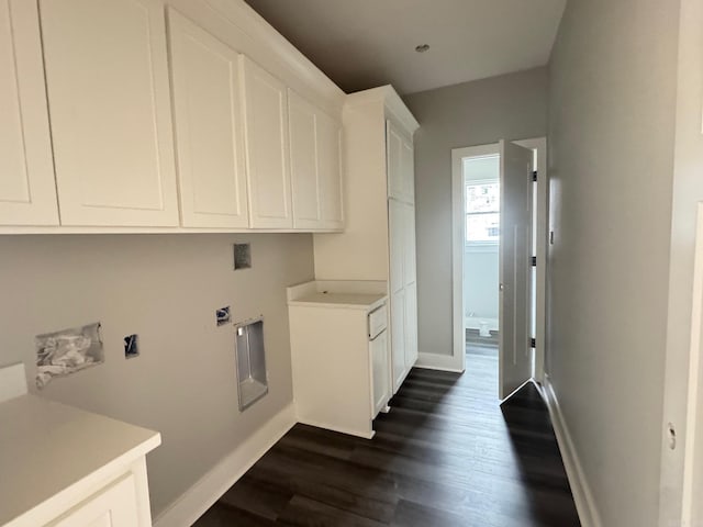 washroom with baseboards, dark wood finished floors, and cabinet space