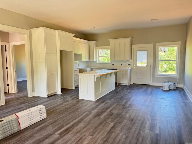 kitchen featuring dark wood finished floors, a kitchen island, tasteful backsplash, and white cabinetry
