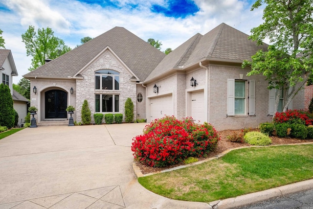 102 Falata Cir, Little Rock, AR 72223 - french country inspired facade featuring stone siding, a front yard, driveway, and a garage