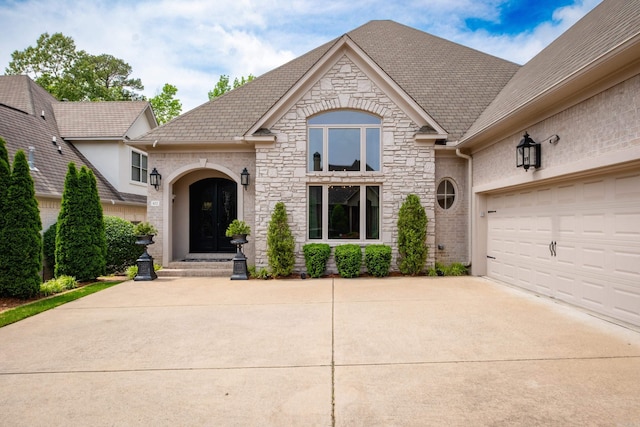 102 Falata Cir, Little Rock, AR 72223 - french country inspired facade featuring stone siding, a high end roof, driveway, and a garage