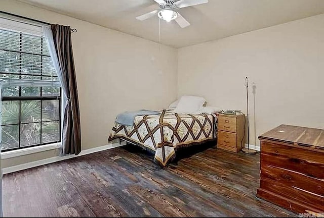 bedroom with baseboards, dark wood-style floors, and a ceiling fan