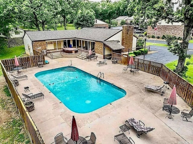 community pool featuring a fenced backyard and a patio