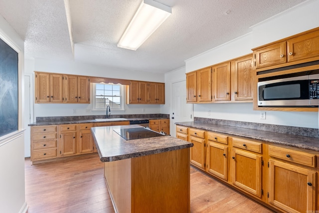 122 Apple Blossom Loop, Maumelle, AR 72113 - kitchen featuring stainless steel microwave, a sink, a textured ceiling, a center island, and dark countertops