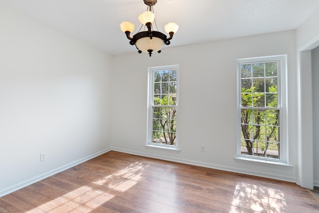 122 Apple Blossom Loop, Maumelle, AR 72113 - unfurnished room with an inviting chandelier, baseboards, and hardwood / wood-style floors