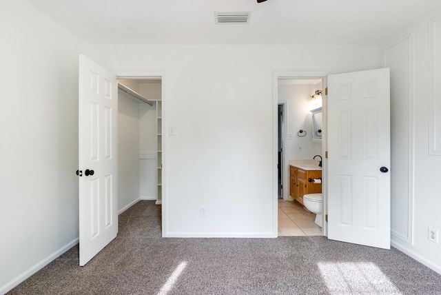 122 Apple Blossom Loop, Maumelle, AR 72113 - unfurnished bedroom featuring a sink, ensuite bathroom, light colored carpet, visible vents, and a walk in closet
