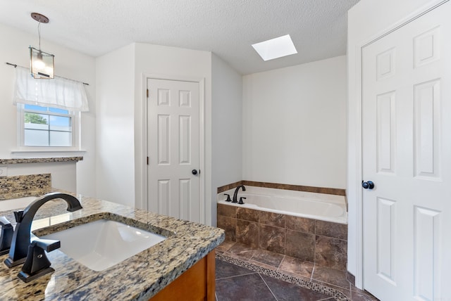 122 Apple Blossom Loop, Maumelle, AR 72113 - full bathroom featuring a skylight, vanity, a textured ceiling, tile patterned floors, and a bath