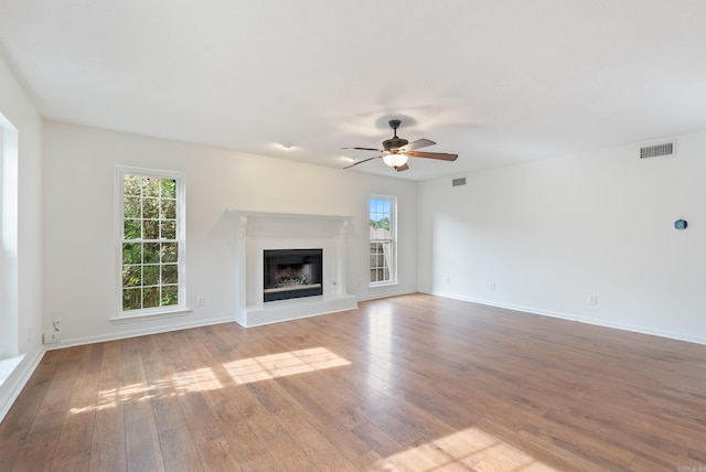 122 Apple Blossom Loop, Maumelle, AR 72113 - unfurnished living room featuring a glass covered fireplace, hardwood / wood-style floors, a ceiling fan, and visible vents