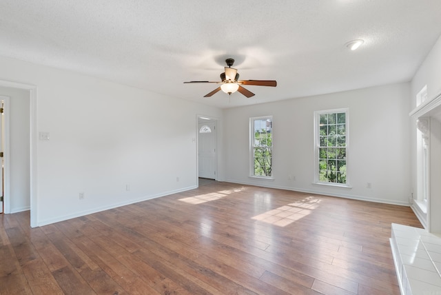 122 Apple Blossom Loop, Maumelle, AR 72113 - unfurnished living room with ceiling fan, a textured ceiling, wood-type flooring, and baseboards