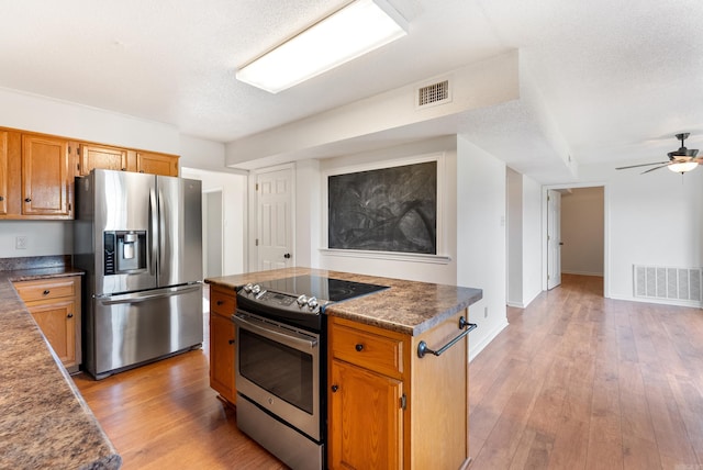 122 Apple Blossom Loop, Maumelle, AR 72113 - kitchen featuring ceiling fan, stainless steel appliances, visible vents, and light wood-style floors