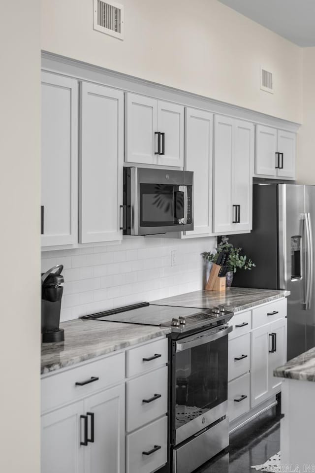 920 Park St, Little Rock, AR 72202 - kitchen with light stone countertops, decorative backsplash, stainless steel appliances, and visible vents