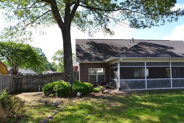 3810 Hanover Dr, Bryant, AR 72022 - rear view of property featuring a sunroom, a yard, fence, brick siding, and roof with shingles