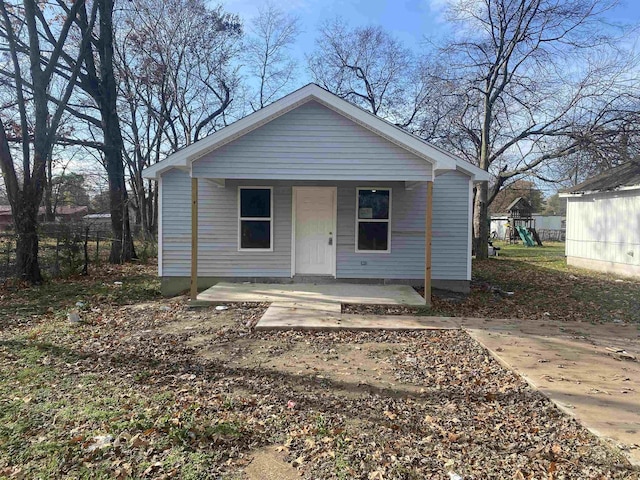 bungalow featuring covered porch and fence