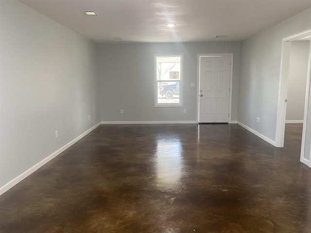 empty room featuring baseboards and finished concrete flooring