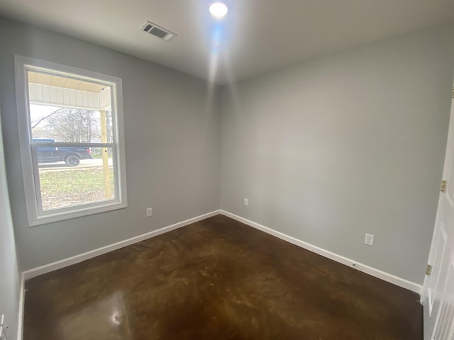 empty room featuring visible vents, concrete flooring, and baseboards