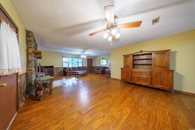140 Bird Dove Ln, Heber Springs, AR 72543 - living area featuring wood finished floors, a textured ceiling, visible vents, ceiling fan, and wainscoting