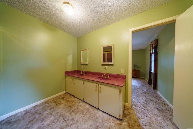 140 Bird Dove Ln, Heber Springs, AR 72543 - bathroom with double vanity, a textured ceiling, baseboards, and a sink