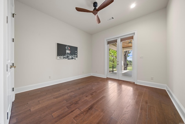 spare room featuring baseboards, visible vents, dark wood-style flooring, and a ceiling fan