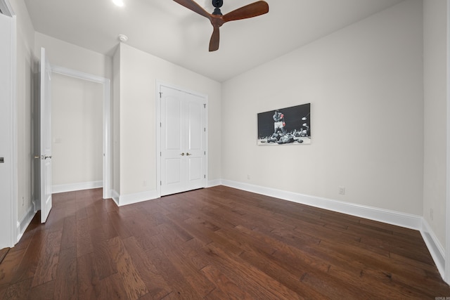 unfurnished bedroom with dark wood-type flooring, baseboards, and a ceiling fan