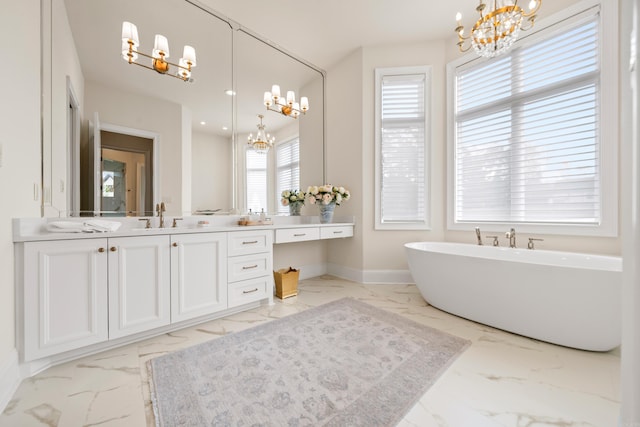bathroom featuring a chandelier, a soaking tub, and marble finish floor