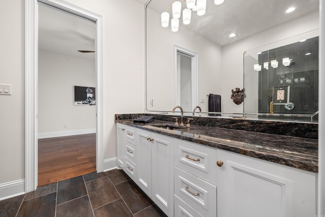 bathroom with a stall shower, baseboards, vanity, and recessed lighting