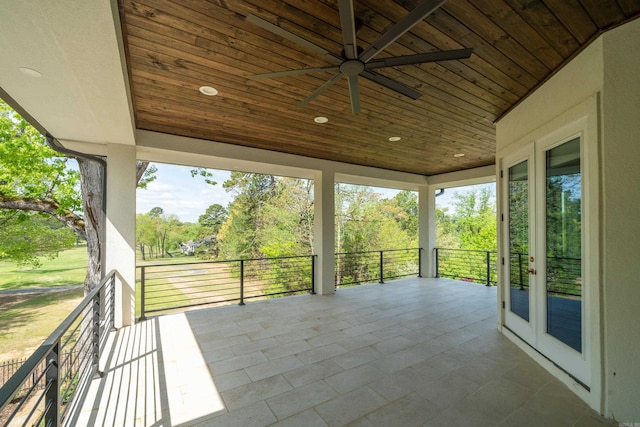 unfurnished sunroom with wood ceiling, french doors, and ceiling fan