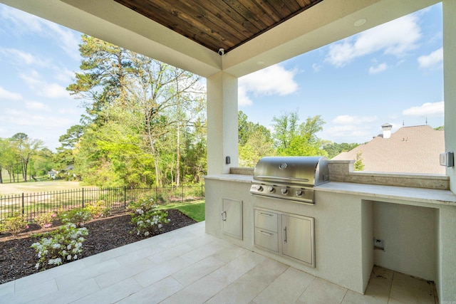 view of patio featuring exterior kitchen, grilling area, and fence
