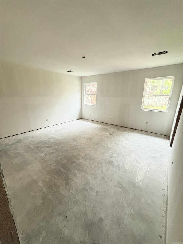 empty room with unfinished concrete flooring
